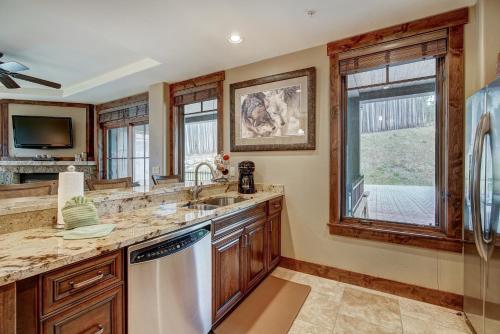 a kitchen with a sink and a dishwasher at True Ski-in Ski-out Luxury Condo on Peak 7 condo in Breckenridge