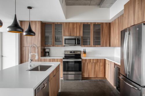 a kitchen with wooden cabinets and a stainless steel refrigerator at Kasa 2nd Street Austin in Austin