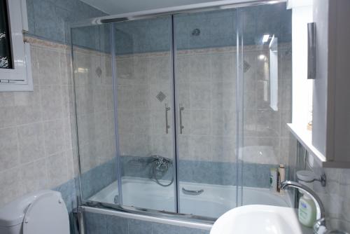 La salle de bains est pourvue d'une douche avec une porte en verre. dans l'établissement Agathi's house, à Mitikas