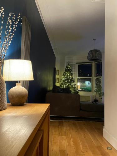 uma sala de estar com uma árvore de Natal e um sofá em The Clock Tower Apartment - Spacious, Modern, 2 bed Apartment , Southsea with Free parking - sleeps 4 em Portsmouth