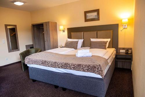 1 dormitorio con 1 cama grande en una habitación de hotel en City Hotel Wiesbaden, en Wiesbaden