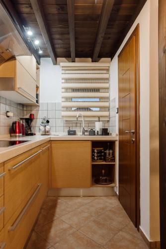 a kitchen with wooden cabinets and a sink at Volos luxury maisonette-Pelion view in Volos