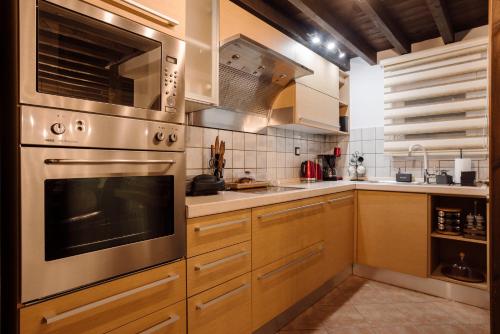 a kitchen with wooden cabinets and stainless steel appliances at Volos luxury maisonette-Pelion view in Volos