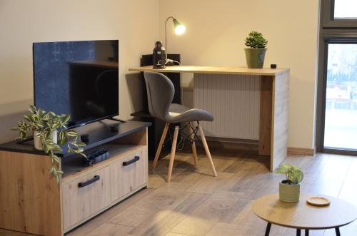 uma sala de estar com uma televisão e uma secretária em Roof Terrace Old Town Apartments with private parking em Gdansk