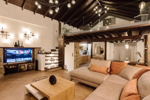 a living room with a couch and a tv at Volos luxury maisonette-Pelion view in Volos