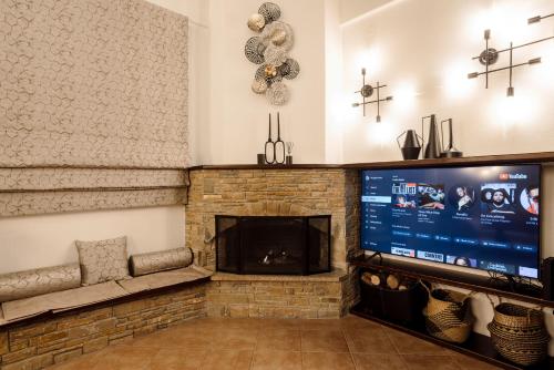 a living room with a fireplace and a flat screen tv at Volos luxury maisonette-Pelion view in Volos