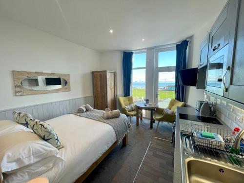 1 dormitorio con 2 camas y cocina con fregadero en Sunnybeach Holiday Apartments, en Paignton