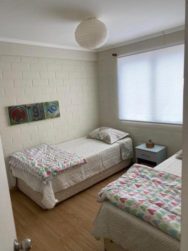 a bedroom with two beds and a window at Hermosa casa en la serena in La Serena