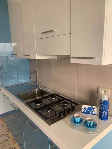 a kitchen with a stove with two cups on it at Mare Azzurro Appartamento in Sciacca
