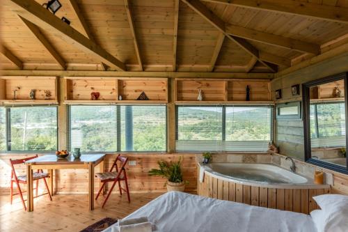 a room with a tub in a wooden house at שיר החורש in Shomera