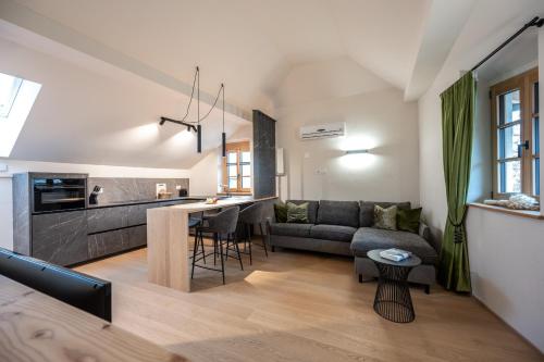 a living room and kitchen with a couch and a table at Schmitte am Sonnenwirtsplatz in Eppan an der Weinstraße - perfect starting point for hikes and bike tours in Appiano sulla Strada del Vino