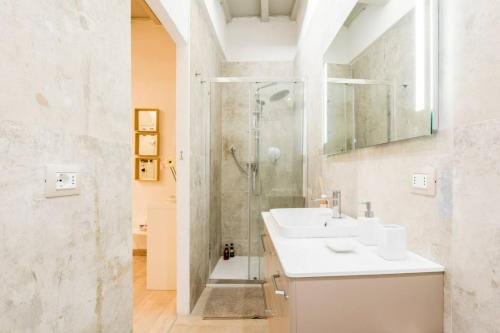La salle de bains blanche est pourvue d'une douche et d'un lavabo. dans l'établissement Cozy apartment near Ponte Vecchio, à Florence
