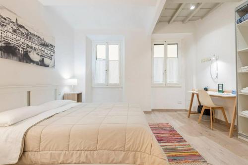 - une chambre blanche avec un grand lit et un bureau dans l'établissement Cozy apartment near Ponte Vecchio, à Florence