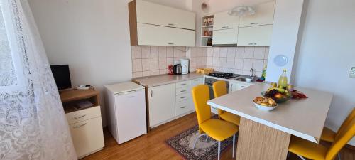 uma pequena cozinha com uma mesa e cadeiras amarelas em Apartmani Gizela em Trogir