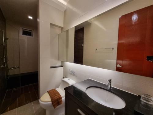 uma casa de banho com um lavatório, um WC e um espelho. em Tinker Bell Pool Villa em Praia de Jomtien
