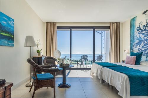 a hotel room with a bed and a table and a window at Hotel Miba in Salobreña