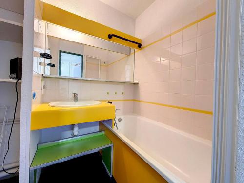 ein Badezimmer mit einem gelben Waschbecken und einer Badewanne in der Unterkunft Appartement Les Menuires, 2 pièces, 4 personnes - FR-1-344-1078 in Les Menuires