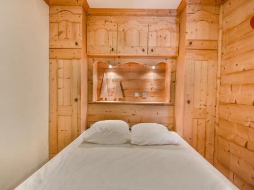 - une chambre dotée de murs en bois et d'un lit avec deux oreillers dans l'établissement T3 + Coin Montagne Rénové Proche Centre, 6 Pers, Parking, Navettes Gratuites, Les Gets - FR-1-685-13, aux Gets