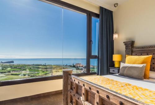 a bedroom with a bed and a large window at Hotel Miba in Salobreña