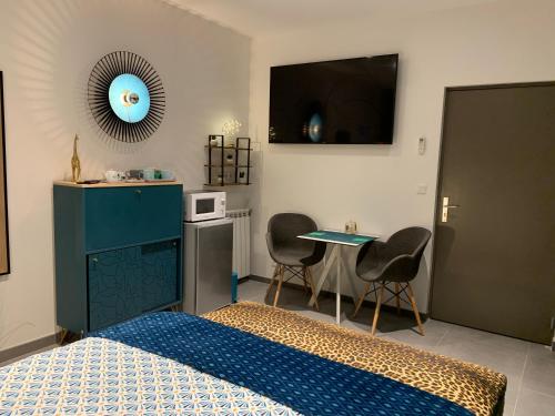 une chambre avec un lit, une table et une télévision dans l'établissement La CORSA CHAMBRE FAMILIALE DELUXE, à Narbonne