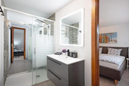 baño con lavabo, cama y espejo en Casa Hola Mar en Los Realejos