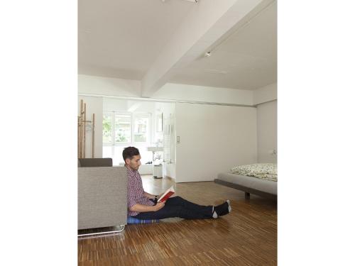 a man sitting on the floor with a book at Basel Backpack in Basel