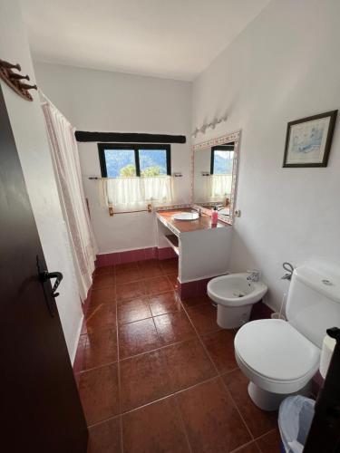 a bathroom with a toilet and a sink and a tub at Casa Jara in Jimera de Líbar