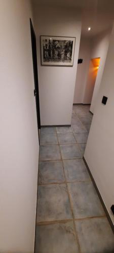 a hallway with white walls and a tile floor at Nez sur la croisette. in Dinant