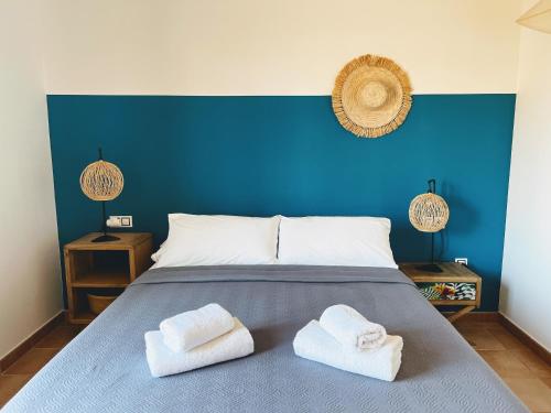 a blue bedroom with two towels on a bed at Alma Ventura House Majanicho iRent Fuerteventura in Lajares