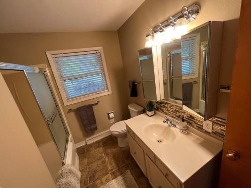 a bathroom with a sink and a toilet and a mirror at Spacious 4 bedroom residential at Burlington Park in Billings