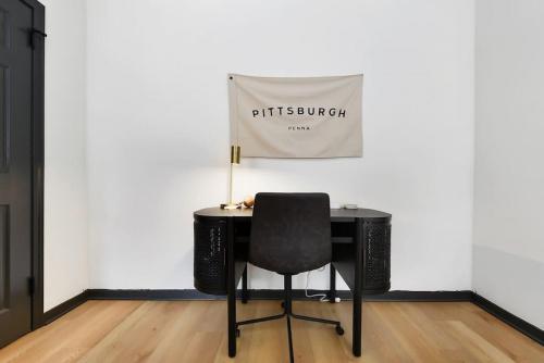 a desk with a chair in front of a white wall at HostWise Stays - Butler St, Lower Lawrenceville, Brand New! in Pittsburgh