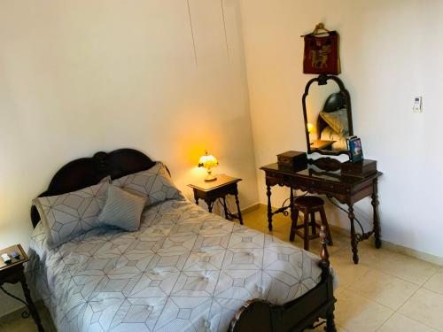 Schlafzimmer mit einem Bett und einem Tisch mit einem Spiegel in der Unterkunft La Casa de Leo Recamara 1 Villa Cardiell QROO in Playa del Carmen