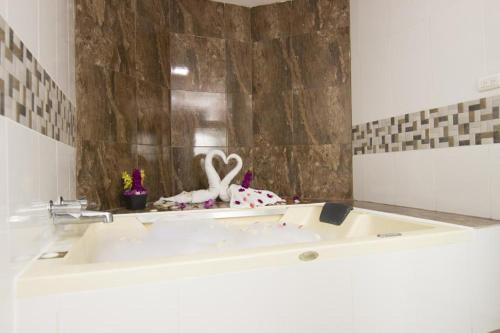 a bathroom with a bath tub with two swans on it at Hotel Gold Premium in Bonao