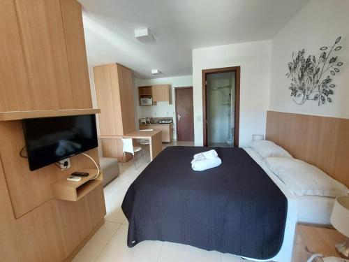 a small room with a bed and a television at The Sun Flat Beira Lago in Brasília