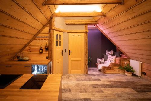 an attic room with a yellow door and a couch at Nadleśniczówka - Bieszczadzka Zagroda in Weremień