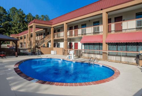 a large swimming pool in front of a hotel at Red Roof Inn Tupelo in Tupelo