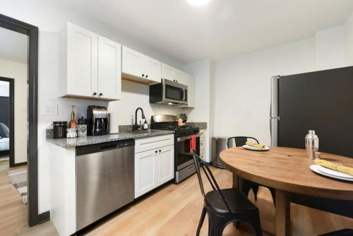 a kitchen with a table and a black refrigerator at HostWise Stays - Pet Friendly Butler St Apt, Ground Floor with Private Entrance in Pittsburgh