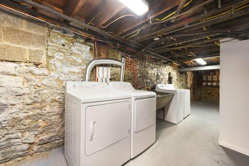 een wasruimte met 2 wastafels en een stenen muur bij HostWise Stays - Pet Friendly Butler St Apt, Ground Floor with Private Entrance in Pittsburgh