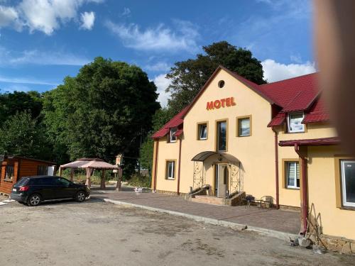 um edifício com um carro estacionado em frente em Мотель «Паляниця» 