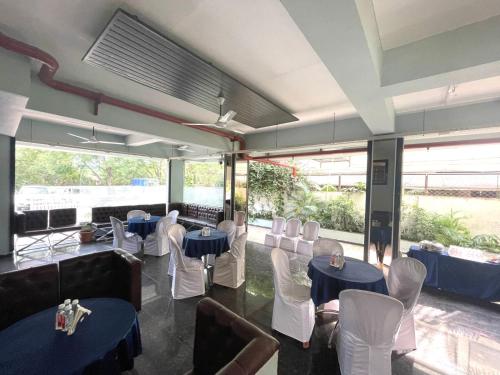 un restaurante con mesas azules y sillas blancas en HOTEL AIRPORT KK, en Nagpur