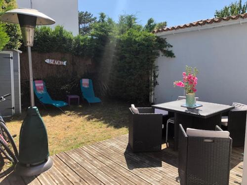 patio ze stołem i krzesłami na tarasie w obiekcie Agréable maison, plage à 400m, jardin, piscine et tennis w mieście Saint-Palais-sur-Mer