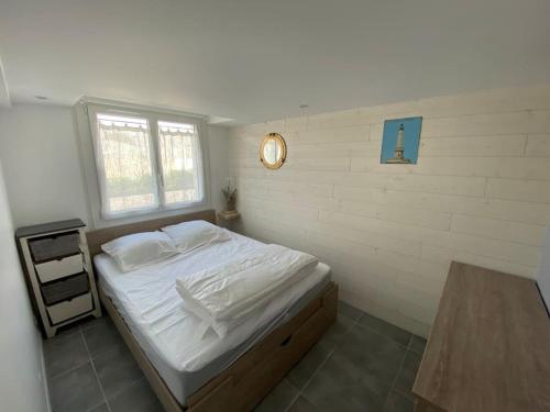 - une chambre avec un lit blanc et une table en bois dans l'établissement Agréable maison, plage à 400m, jardin, piscine et tennis, à Saint-Palais-sur-Mer