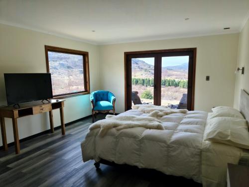 um quarto com 2 camas, uma secretária e uma televisão em Hotel HORSTMEYER em Cochrane