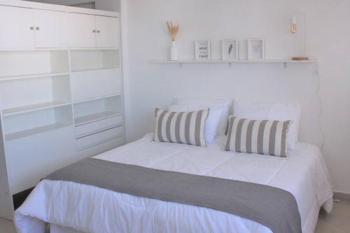 1 dormitorio blanco con 1 cama con 2 almohadas en JUNI0904 Moderno y Espectacular Depto Entero en Recoleta en Buenos Aires