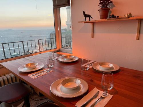 un tavolo con piatti e bicchieri su un tavolo con vista di Art Loft , 270* full sea view in Cihangir a Istanbul