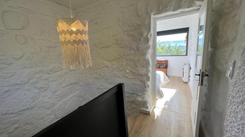una sala de estar con una lámpara de araña colgada de una pared en Casas do Pinheiro Grande, en Fornos de Algodres