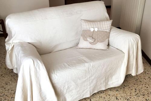 a white couch with a pillow on it at Casa Graziella - appartamento con parcheggio privato in Montepulciano