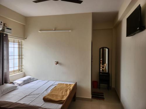 a bedroom with a bed and a flat screen tv at Raja Rani Mahal Ac-Rooms in Tiruvannāmalai
