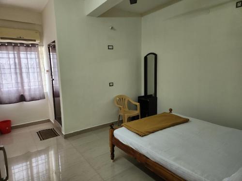 a bedroom with a bed and a chair in it at Raja Rani Mahal & Residency in Tiruvannāmalai