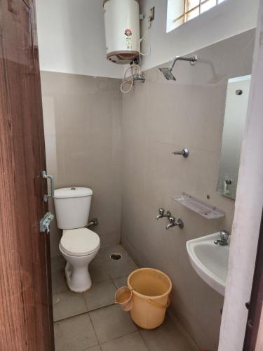 a small bathroom with a toilet and a sink at Raja Rani Mahal Ac-Rooms in Tiruvannāmalai